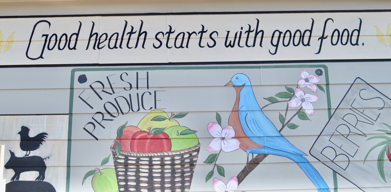 The Truck Patch Natural Market exterior is decorated with colorful murals painted by local artists Kathy Grigsby and Cindy Temple, advertising organic produce and humanely raised, grass fed, free range livestock.